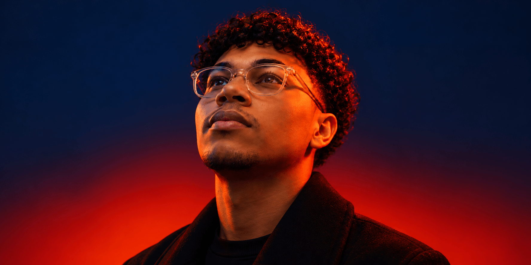 Retrato de Joalesf con iluminación azul y naranja, mirando hacia arriba